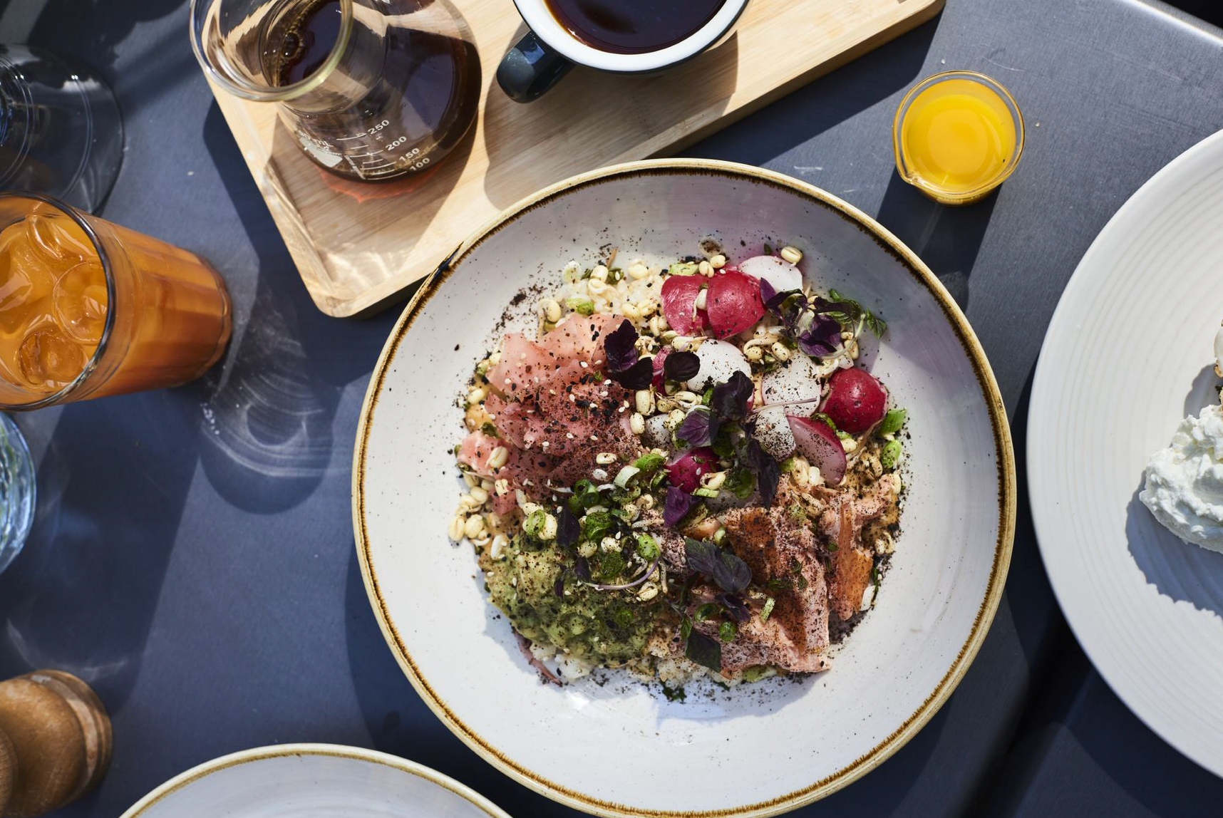 Outdoor dining and salmon rice bowl at Caravan Canary Wharf restaurant