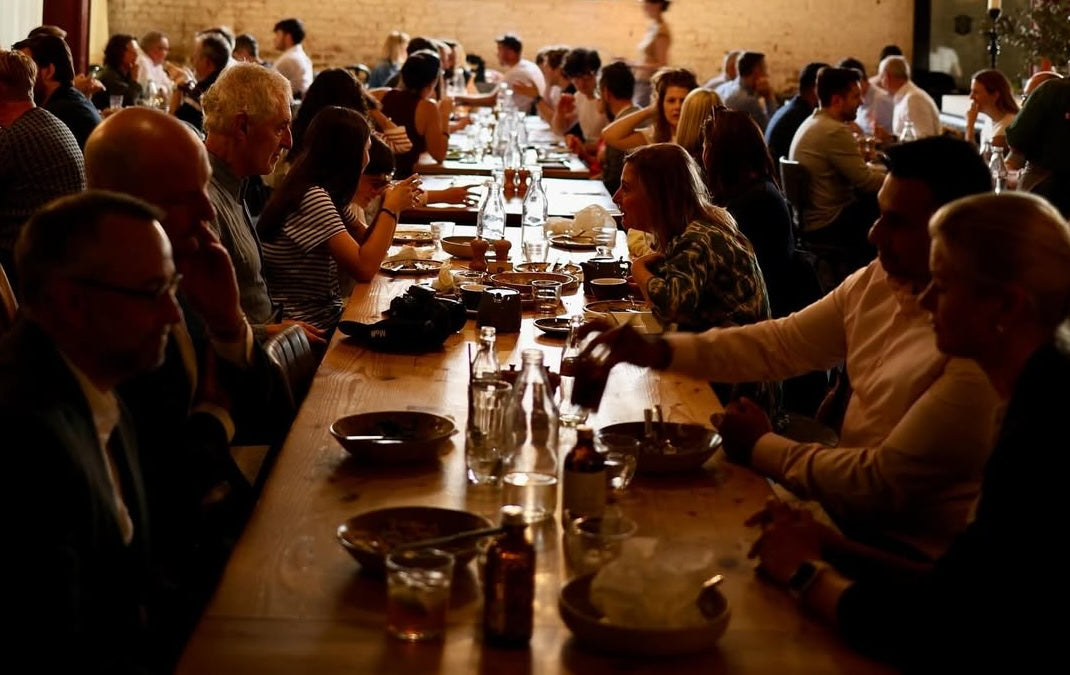 People sitting at long tables eating in Caravan King's Cross
